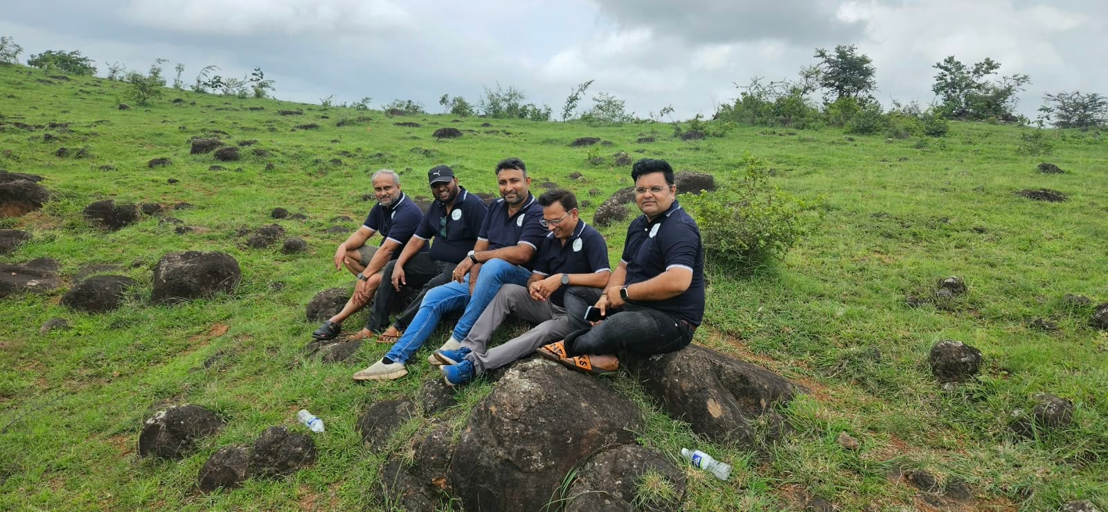 Shwas Foundation team members sitting together on a green hillside