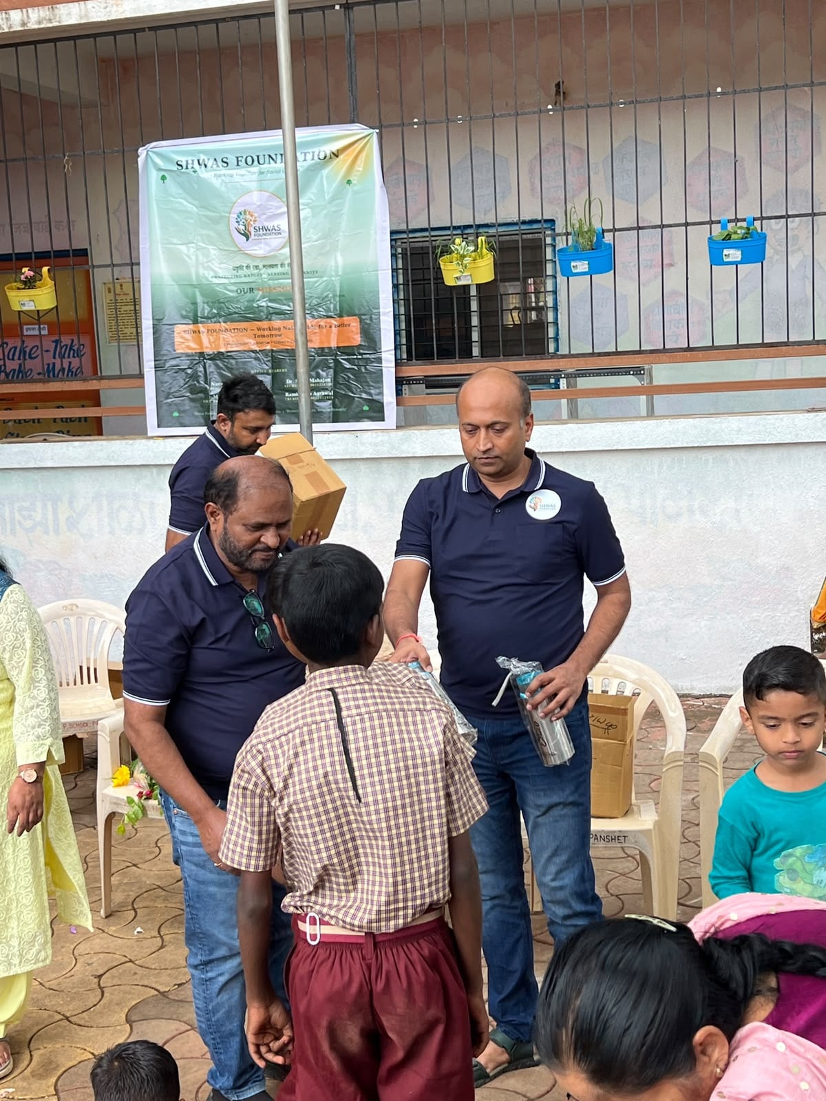 Foundation members handing water bottles to children