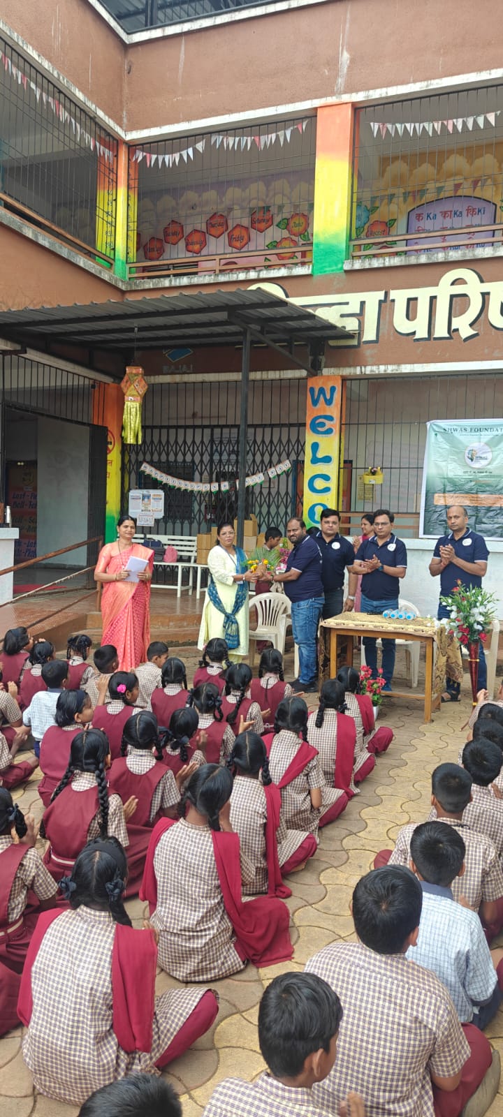 Teachers welcoming foundation members as students gather in the courtyard