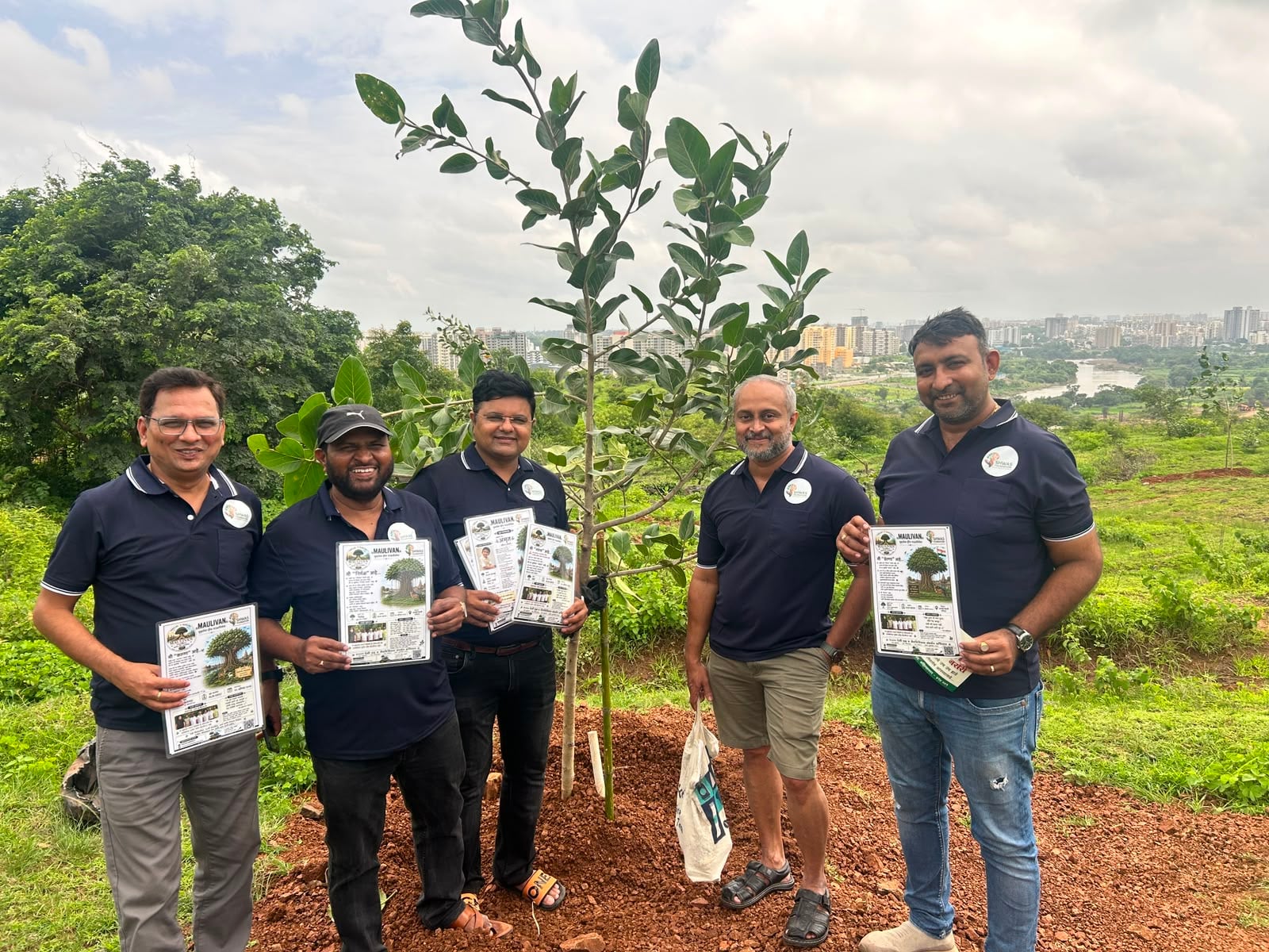 Foundation members with Maulivan tree information leaflets beside a newly planted sapling
